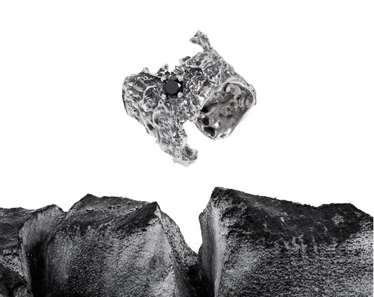 A textured, molten-style silver ring with a black gemstone set in the center.