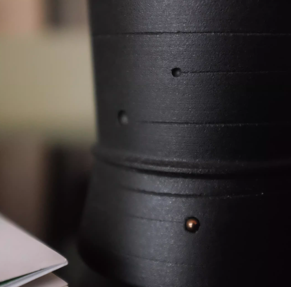 Close-up of a black cylindrical object with a textured surface
