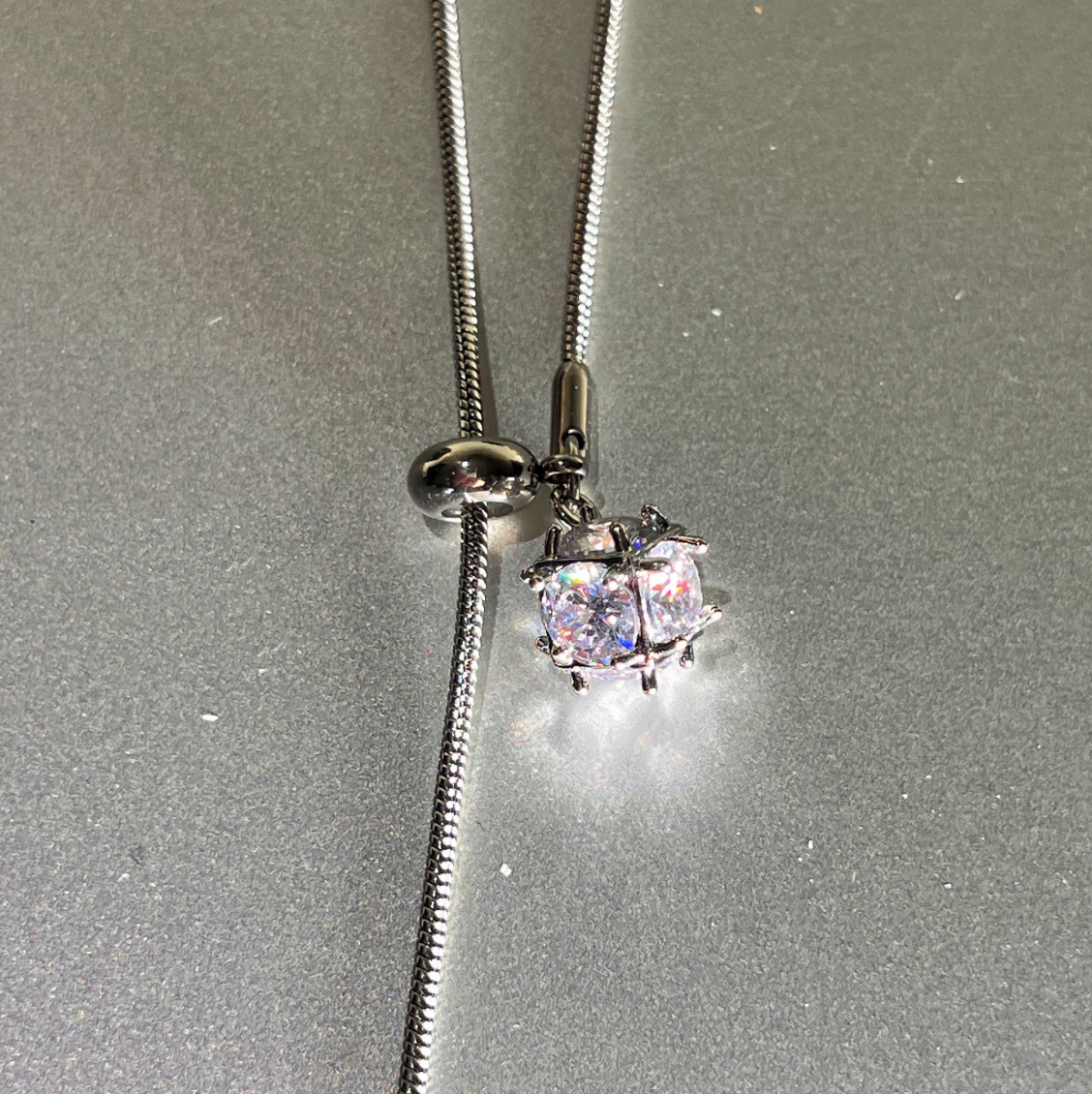 Necklace with a sparkling pendant on a gray background