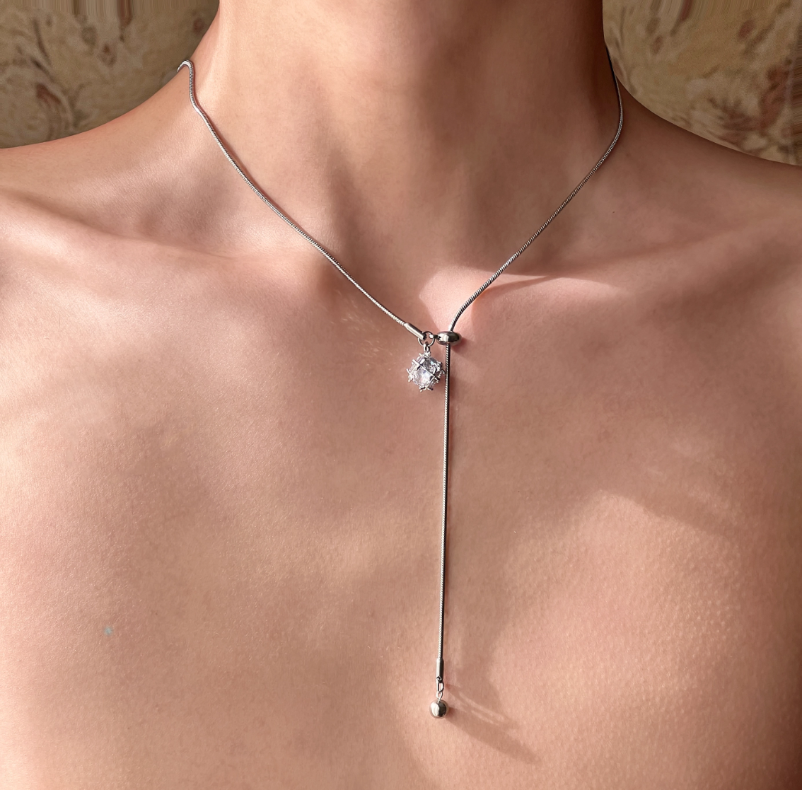 Silver necklace with a star-shaped pendant on a person's neck