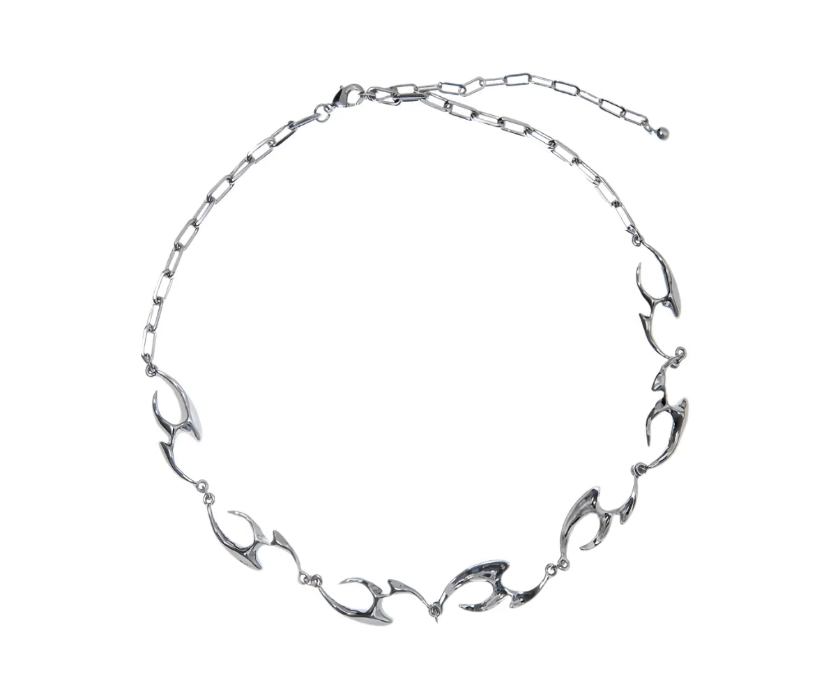 Silver necklace with leaf-like links on a white background