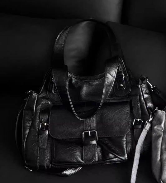 Black leather bag with a strap on a dark background