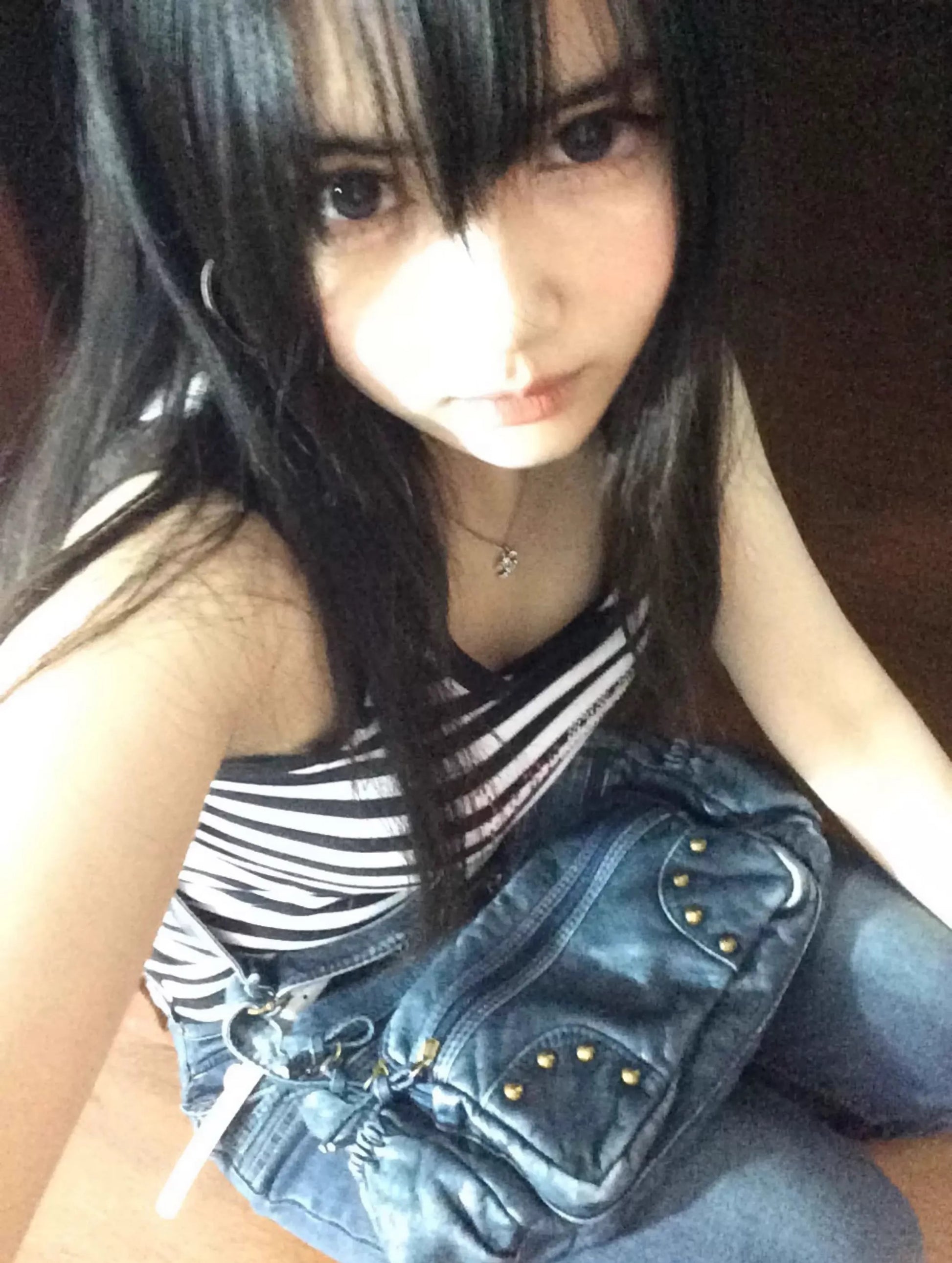 Person wearing a striped top and denim jacket indoors
