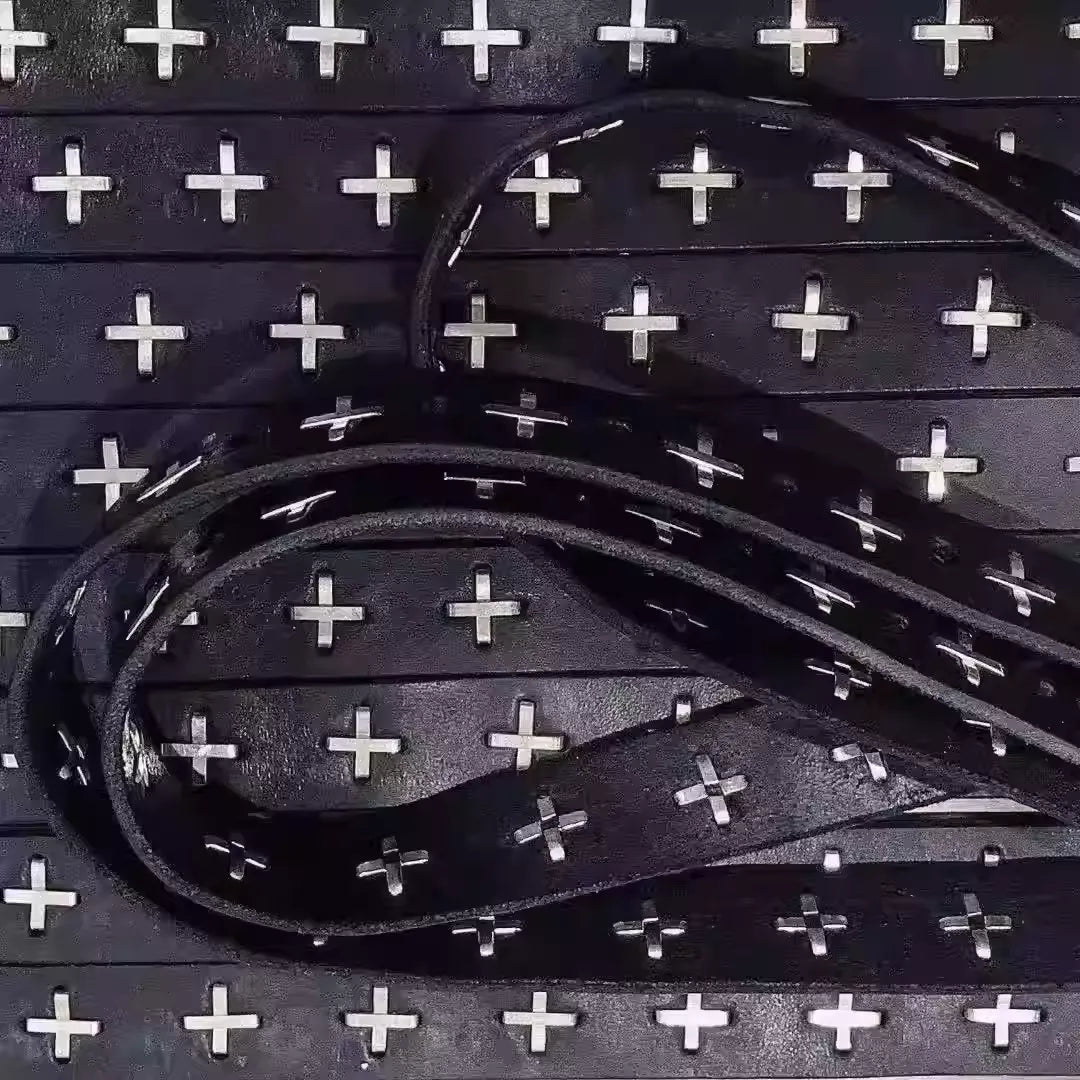 Black leather belt with silver cross studs on a black background