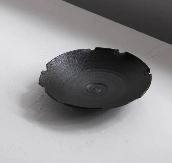 Black ceramic bowl on a light gray surface